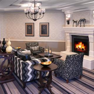 A cozy living room with a warm fireplace and stylish patterned furniture.