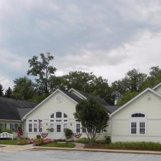 Suburban house with a cloudy sky backdrop and trees surrounding the area.