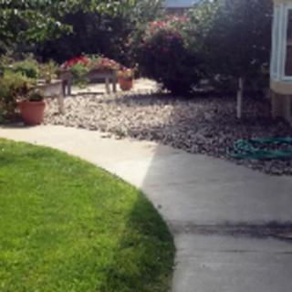 A garden pathway surrounded by a well-maintained lawn and various plants.