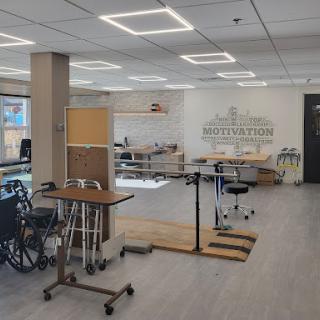 A bright and spacious rehabilitation therapy room equipped with various medical aids.