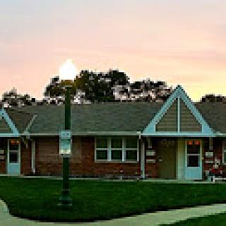 A charming residential building illuminated by a streetlight during sunset.