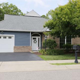 A charming residential home with blue siding and a well-maintained lawn.