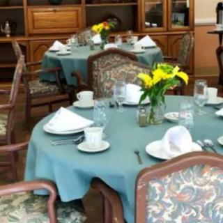 An elegantly set dining table with floral decorations in a restaurant setting.