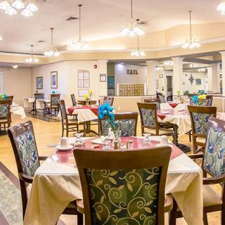 A spacious and elegantly decorated dining room with set tables and chandeliers.