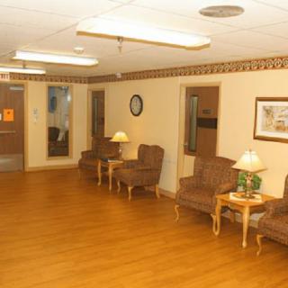 A spacious, well-lit waiting room with comfortable seating and wooden flooring.