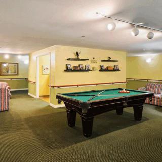 A cozy game room featuring a pool table and comfortable seating.