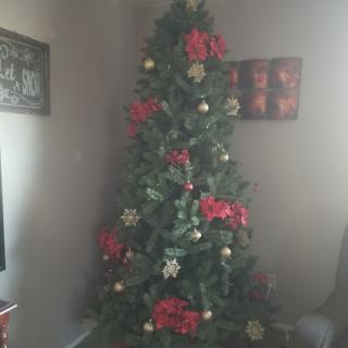 A beautifully decorated Christmas tree adorned with red poinsettias and golden ornaments.