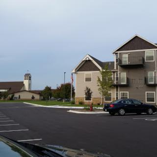 A view of a residential area featuring modern apartment buildings and a parking lot.