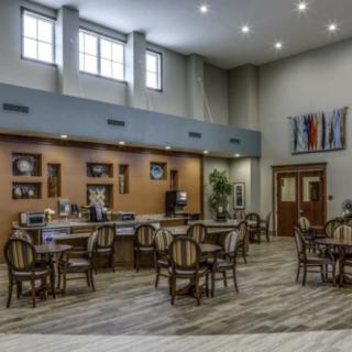 A modern dining area with tables and chairs, featuring elegant decor and ample lighting.