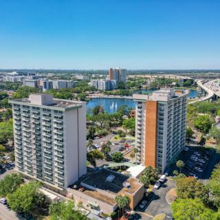 Aerial view of high-rise apartment buildings overlooking a lake in an urban area.