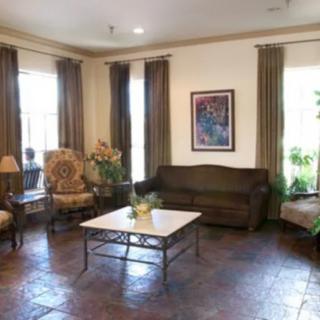 A cozy living room with a sofa, chairs, coffee table, and artwork on the wall.