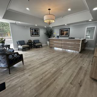 Modern reception area with seating and a wooden desk.