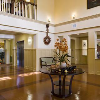 A spacious lobby with a central table adorned with decorative flowers and elegant architectural design.