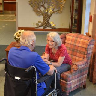 A caregiver engages in a warm conversation with an elderly individual, showcasing moments of companionship and support.