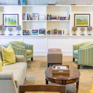 A modern library room with comfortable seating and bookshelves.