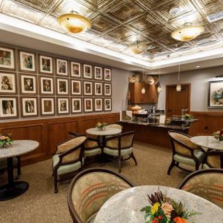 A cozy cafe interior with elegant wall art, comfortable seating, and warm lighting.