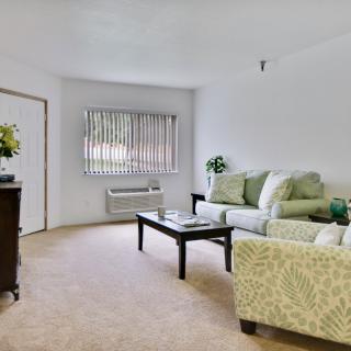 A cozy living room with a sofa, table, and window.