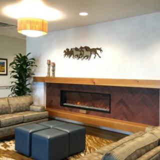 A modern living room with comfortable seating, a sleek fireplace, and decorative artwork.
