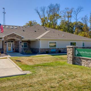 A single-story office building with a sign on the lawn and the American flag displayed outside.