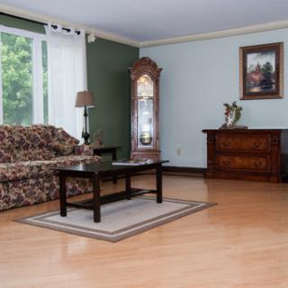 A cozy and well-furnished living room featuring a floral sofa, wooden coffee table, and elegant decor.