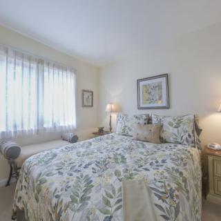 A cozy bedroom with floral bedding and soft lighting.