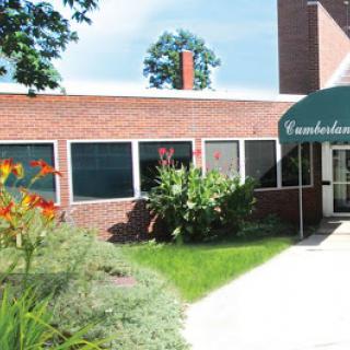A well-maintained brick building with a welcoming entrance and vibrant landscaping.