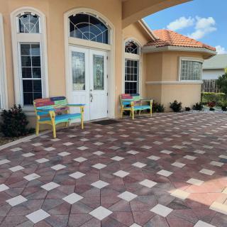 A house entrance with tile flooring and colorful benches on the patio.