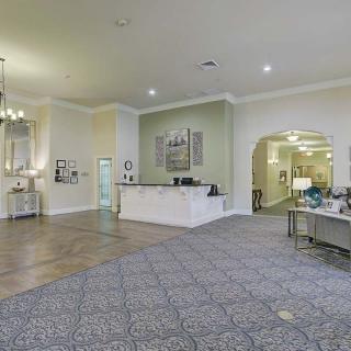 A spacious and elegantly designed lobby with a reception desk and comfortable seating.