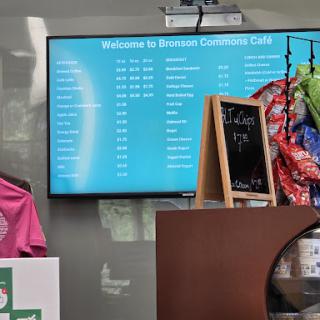 Digital menu board displaying food options in a welcoming cafe environment.