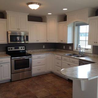 A modern kitchen with white cabinets and stainless steel appliances.