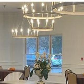 A beautifully arranged dining area with elegant chandeliers and a floral centerpiece.