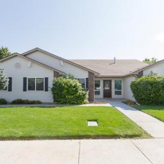 A charming single-story house with a well-maintained front yard.