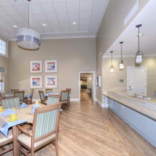 A modern dining room with wooden flooring, stylish furniture, and elegant lighting.