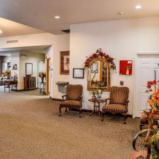 A cozy lobby area with chairs, a decorative mirror, and warm lighting.