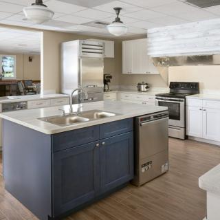A modern kitchen featuring a central island with a double sink, stainless steel appliances, and sleek countertops.