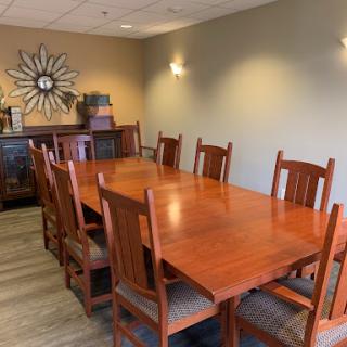 A spacious dining area featuring a large wooden table surrounded by matching chairs, perfect for meetings or gatherings.