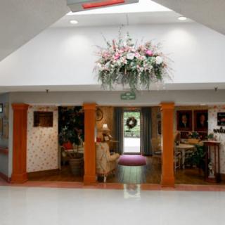 A well-decorated lobby area with floral arrangement and seating.