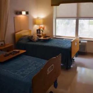 A shared hospital room with two beds equipped for patient care.