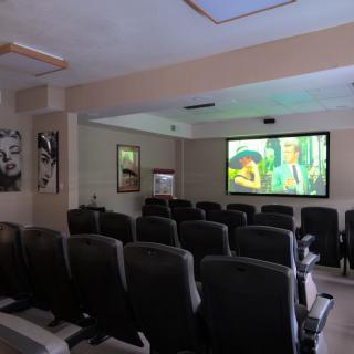 A cozy home theater setup with comfortable seating and a large screen playing a movie.