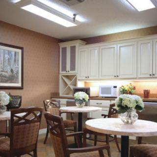 A cozy kitchen dining area with wooden furniture and floral decorations.