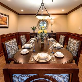 An elegantly decorated dining room with a formal table setting and chandelier lighting.