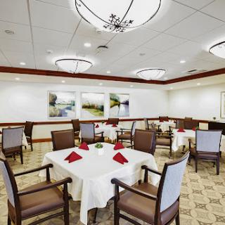 A beautifully arranged dining room with elegantly set tables and tasteful artwork on the walls.