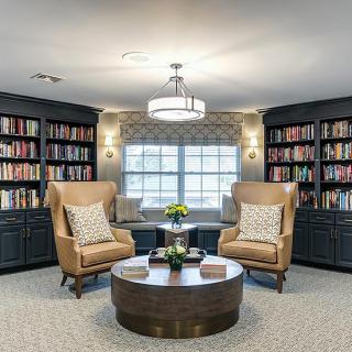 A cozy library space with armchairs and bookshelves, perfect for reading and relaxation.