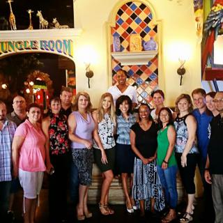 A group of people posing for a photo inside a restaurant with colorful decor.