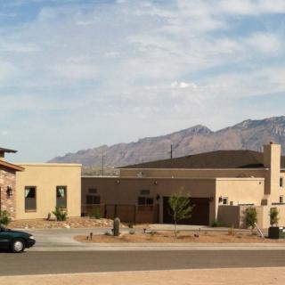 A suburban house set against a mountainous desert landscape.