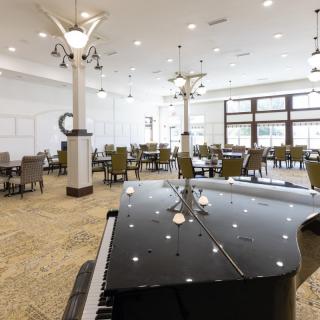A modern dining area featuring a grand piano and contemporary lighting fixtures.