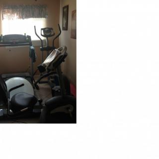 A home gym setup with various exercise machines, including a treadmill and an elliptical.