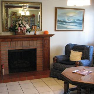 A cozy living room with a fireplace, armchair, and decorative elements.