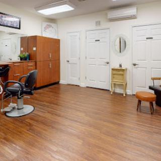 A well-organized salon area featuring stylish chairs, mirrors, and wooden flooring.