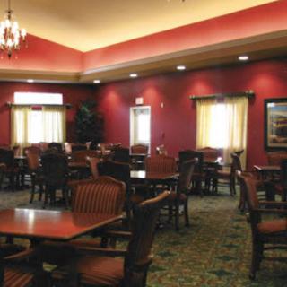 An elegant dining room with red walls, wooden furniture, and soft lighting.